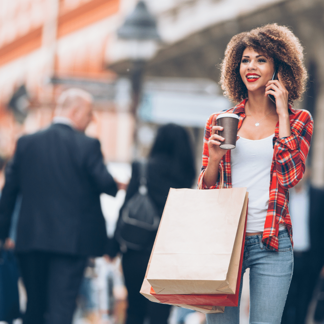 Girl on the phone while carrying shopping bag